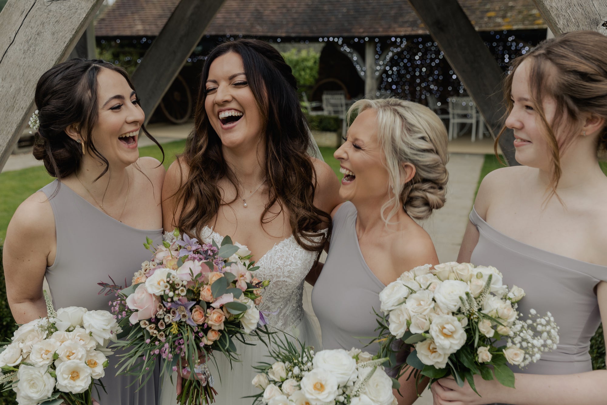 Bride with bridesmaids holding bouquets in a garden setting